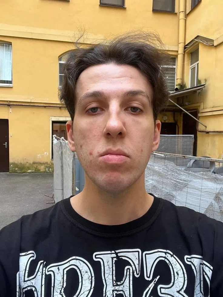 Букер Д. Фред: селфи во дворе-колодце, тёмные волосы, чёрная футболка с белым принтом